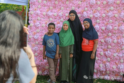 family in front of flower wall