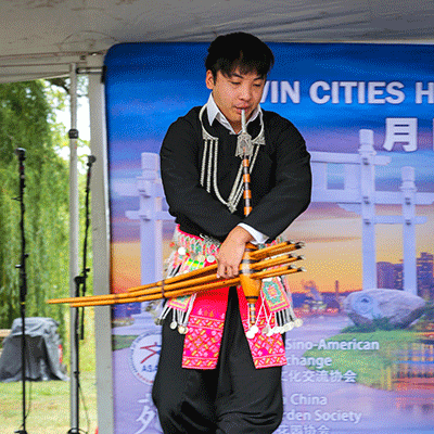 hmong man playing the qeej instrument